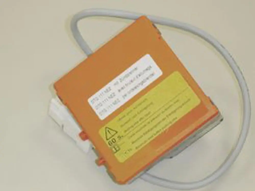 Schwarzes elektrisches Steuergerät von Remeha mit einer orangefarbenen Abdeckung und einem grauen Kabel. Auf der Oberseite sind Warnhinweise und technische Informationen angebracht.